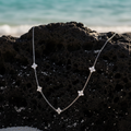 Collier argenté suspendu bord roche volcanique